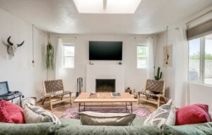 Cozy modern living room with fireplace, TV, and stylish furniture.