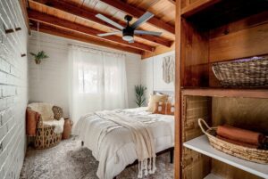 Cozy rustic bedroom with wooden beams and soft bedding.