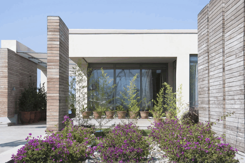 Modern home entrance with large glass doors and brick pillars.