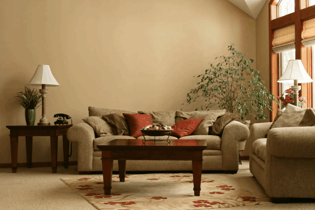Cozy beige living room with a sofa, wooden coffee table, and potted plant.