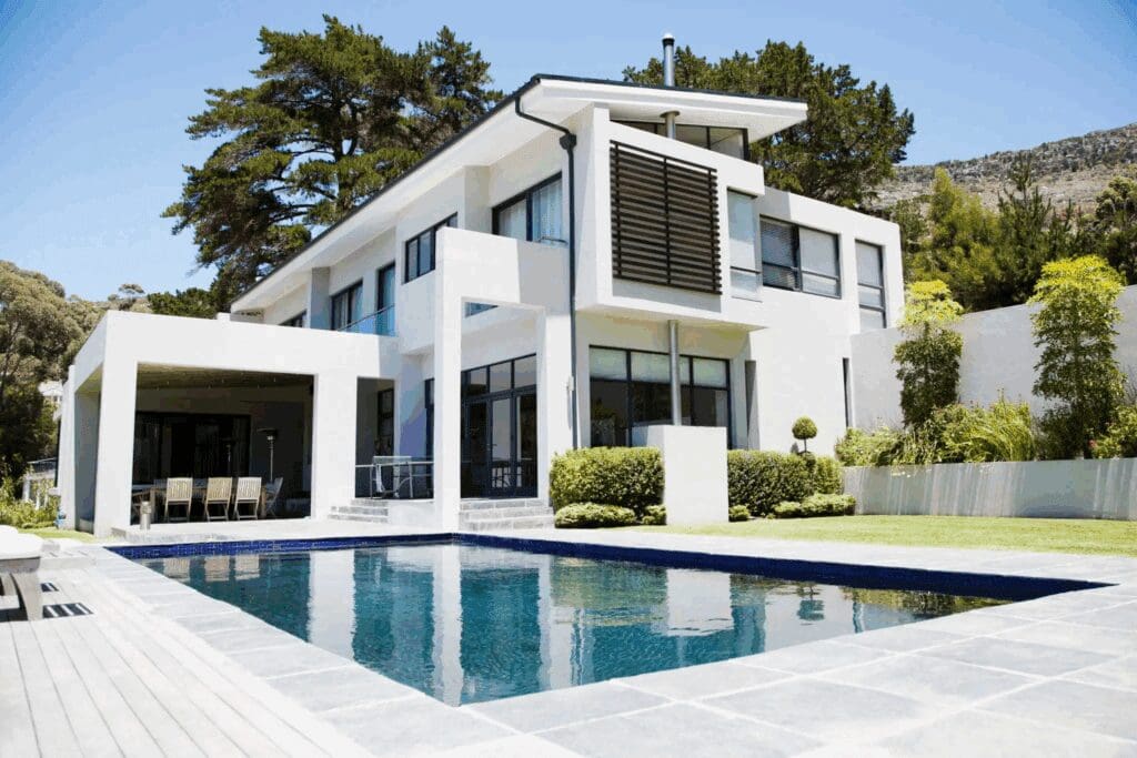 Modern white house with large windows and a swimming pool.