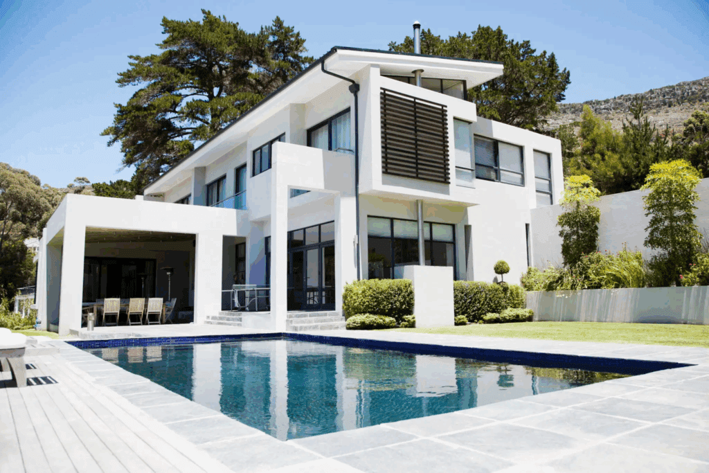 Modern white house with large windows and a swimming pool.