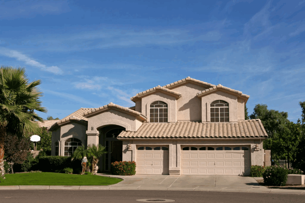 Modern suburban house with a tile roof under a clear blue sky.
