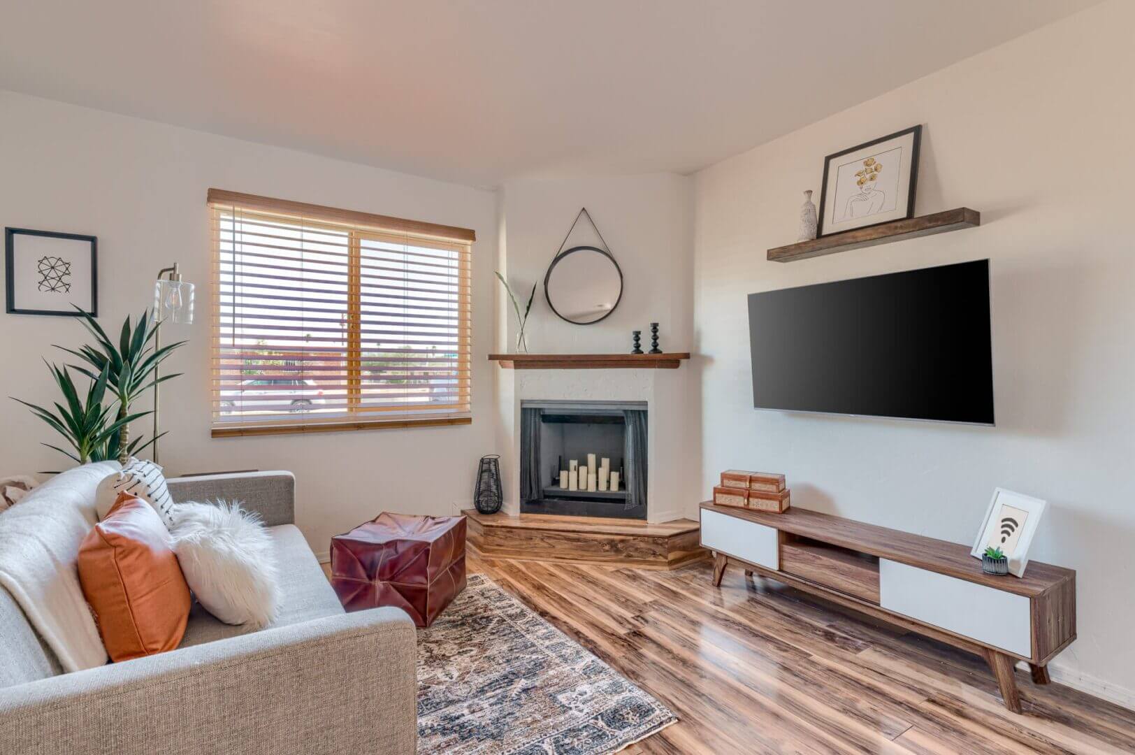 Cozy living room with fireplace, TV, and wooden flooring.
