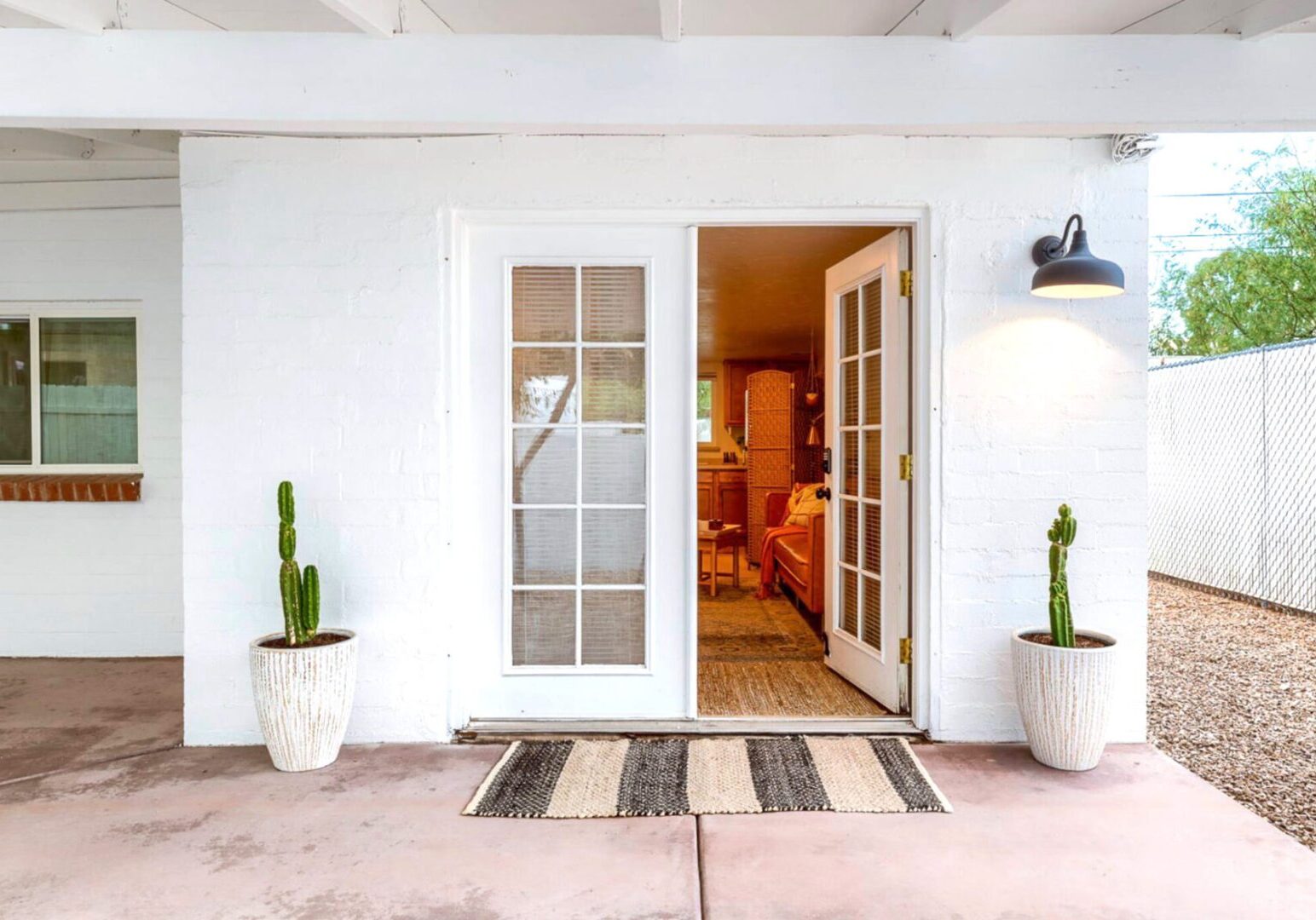 White porch with open French doors, potted cacti