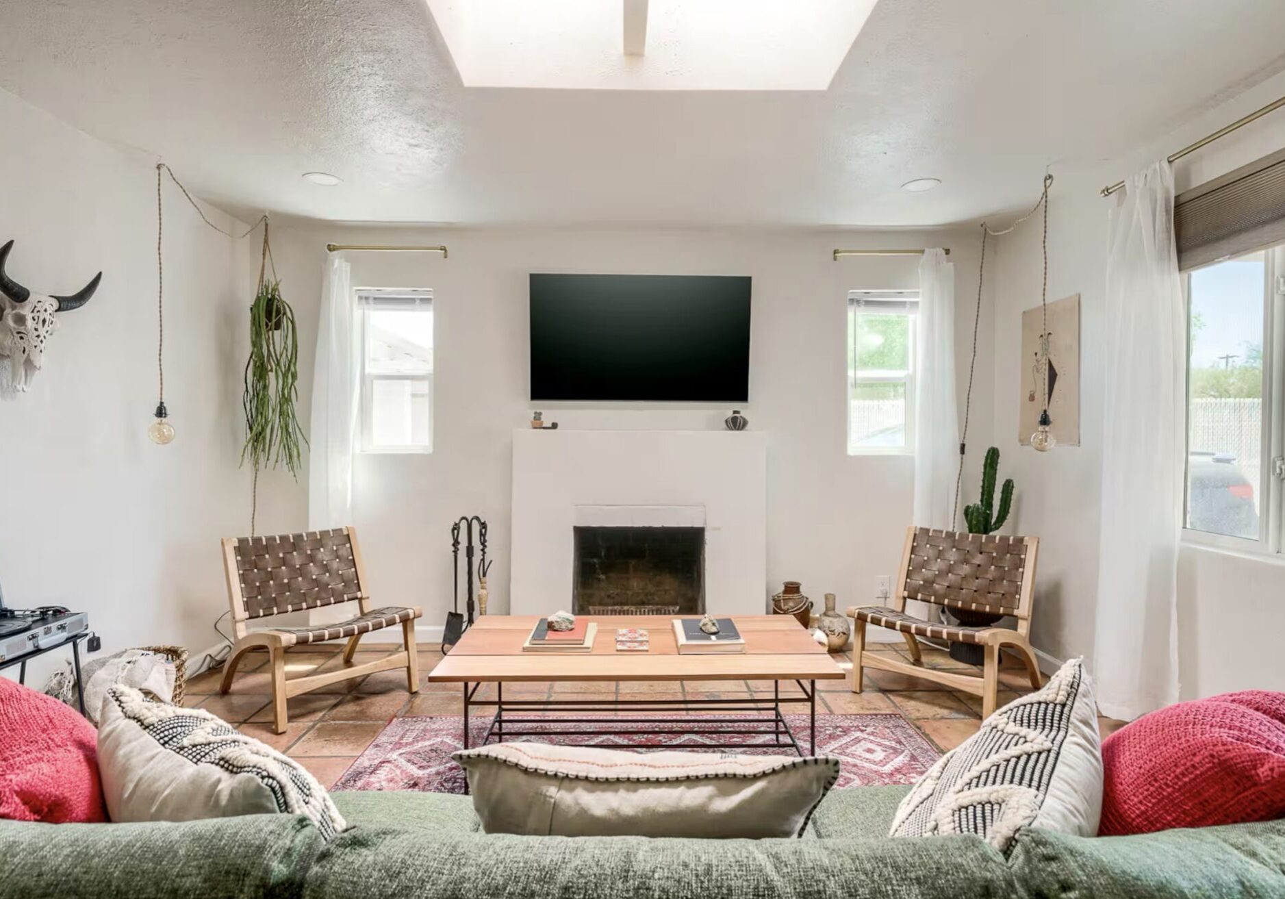 Cozy modern living room with fireplace, TV, and stylish furniture.