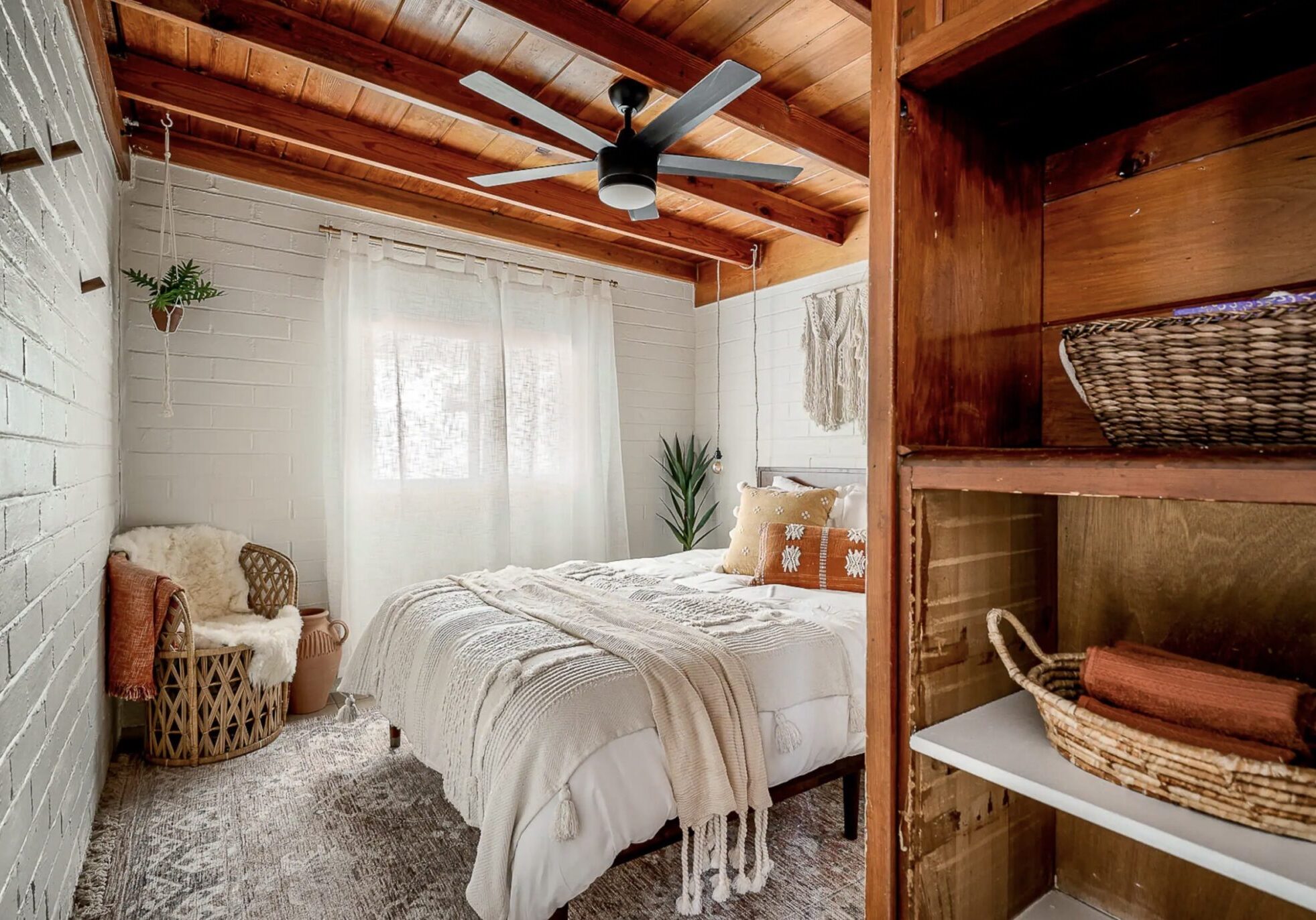 Cozy rustic bedroom with wooden beams and soft bedding.